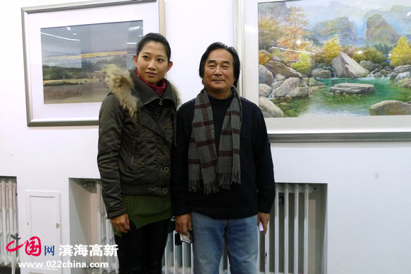 陈重武与青年画家安浚铭在《静物》前留影。