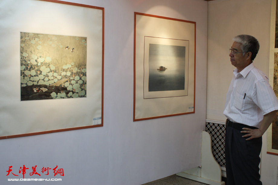 天津人民美术出版社美术馆常务副馆长苏鸿升观赏画作。 