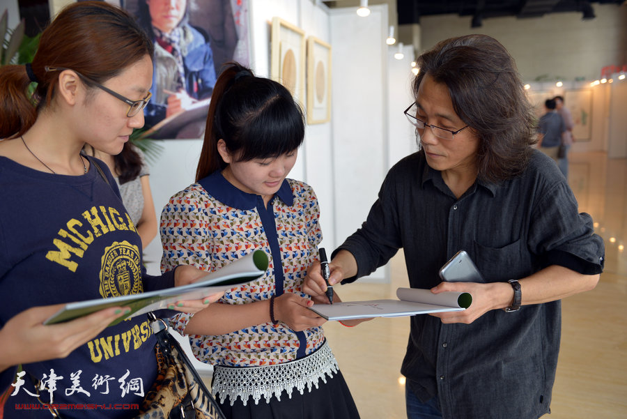 “水墨・月动”今晚书画名家精品展9月8日展出赵均四十幅佳作。图为赵均在画展上为观众签名。