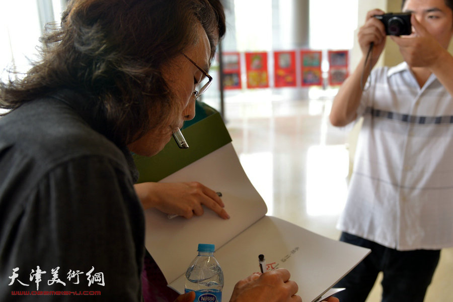 “水墨・月动”今晚书画名家精品展9月8日展出赵均四十幅佳作。图为赵均在画展上为观众签名。