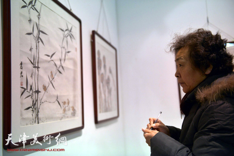 华枝春满—天津美术学院女同学会2014年展暨作品集首发式在六号院艺术馆举行。图为博华在观赏作品。