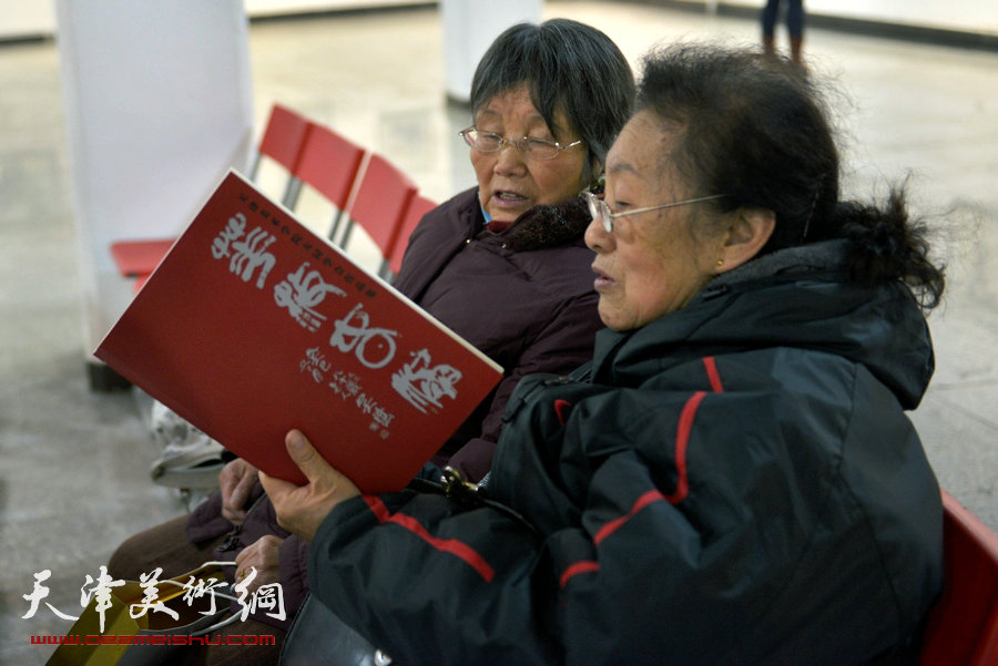 华枝春满—天津美术学院女同学会2014年展暨作品集首发式在六号院艺术馆举行。图为李淑敏、张凤英在观看作品集。