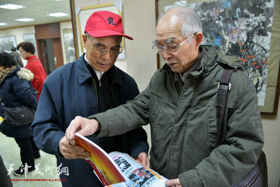 “师法自然—迎新春太行写生作品展”元月4日举行，图为郭文伟在展览现场为观众点评画作。