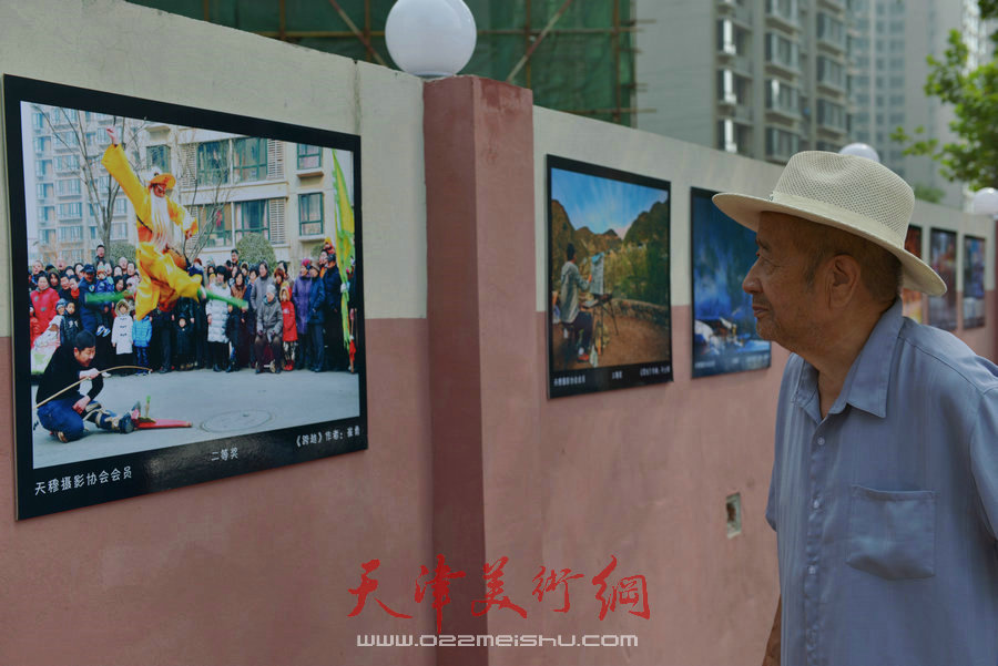 第四届“天穆杯”书画摄影展在北辰区天穆东苑举行，图为天穆村民参观作品。