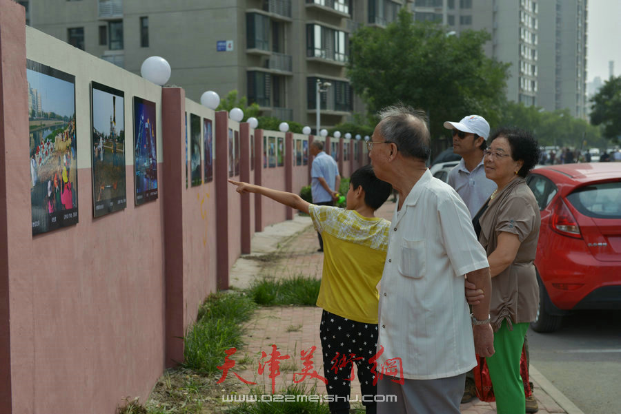 第四届“天穆杯”书画摄影展在北辰区天穆东苑举行，图为天穆村民参观作品。