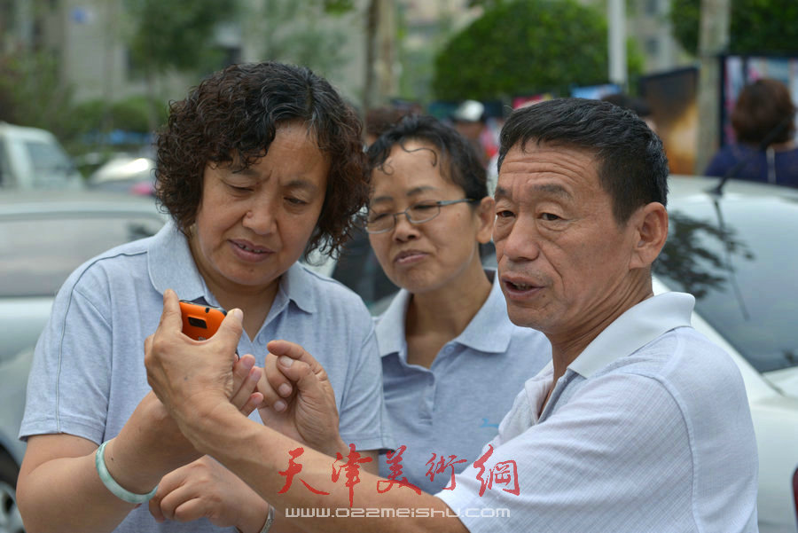 第四届“天穆杯”书画摄影展在北辰区天穆东苑举行，图为观众参观作品。