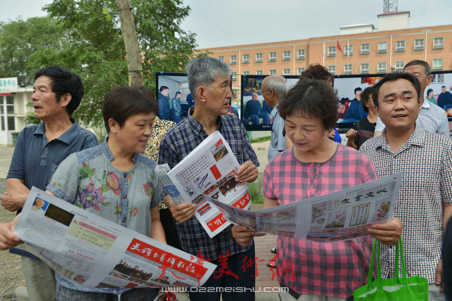 第四届“天穆杯”书画摄影展在北辰区天穆东苑举行，图为观众阅读《天穆书画摄影报》。