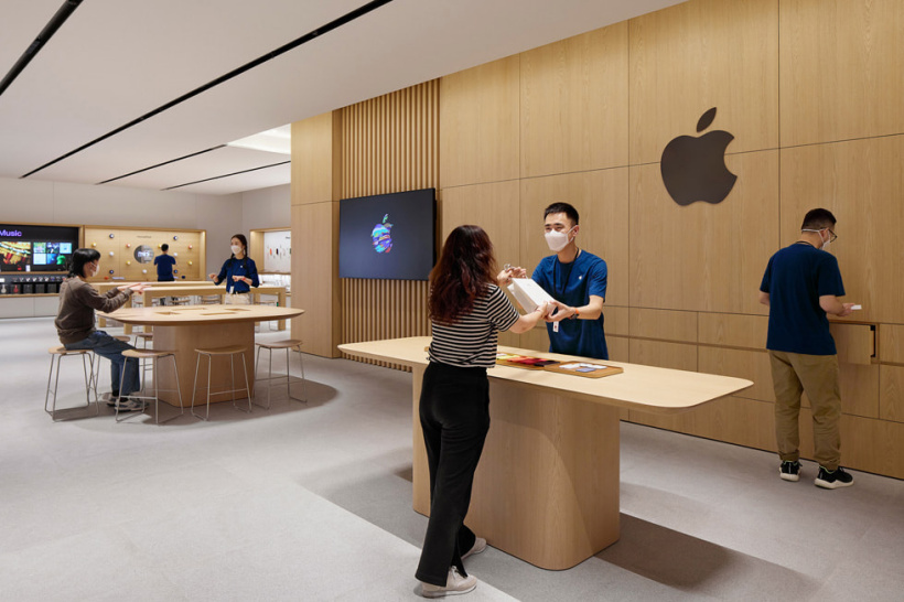 一位顾客正在 Apple 武汉零售店内的 Apple Pickup 到店取货区域取货。