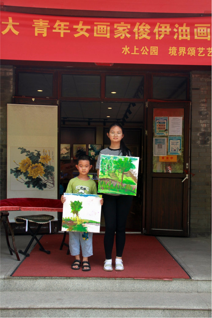 学生陈瑾瑄在在画展现场展示写生的作品
