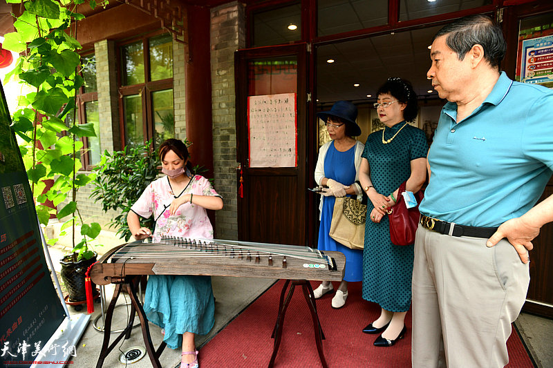 毓峋、李士青、白慧茹在画展现场聆赏古筝技艺传承人陶一菲现场演奏。